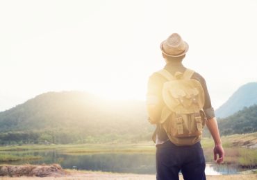 Young Man Traveler with backpack relaxing outdoor.